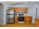 Traditional kitchen features stainless steel refrigerator, black range, and wood cabinetry at 1055 Sunshine Sw Way, Winter Haven, FL 33880