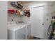 Functional laundry room with washer, dryer, and storage shelves at 1055 Sunshine Sw Way, Winter Haven, FL 33880