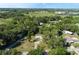 Overhead view of a charming yellow home nestled among mature trees and lush greenery in a peaceful neighborhood at 1163 Lake Dr, Lake Wales, FL 33859