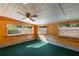 Bonus room with wood walls, green carpet, a ceiling fan and three windows at 1163 Lake Dr, Lake Wales, FL 33859