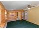 Bonus room with wood walls and green carpet has an exit door at 1163 Lake Dr, Lake Wales, FL 33859