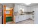 Functional kitchen featuring white cabinets, tile flooring, and easy access to other rooms at 1163 Lake Dr, Lake Wales, FL 33859