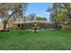 A bright backyard featuring a large screened pool with mature trees providing ample shade at 1226 Lake Loop, Winter Haven, FL 33880