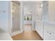 Clean bathroom with shower, white cabinets, and wood-look tile flooring at 1226 Lake Loop, Winter Haven, FL 33880