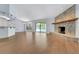 Open living room featuring wood floors, a stone fireplace and plenty of natural light from the sliding glass doors at 1226 Lake Loop, Winter Haven, FL 33880