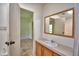 Bathroom vanity with wood cabinets, mirror, and doorway to another room at 1294 1/2 38Th Nw St, Winter Haven, FL 33881