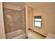 Bathroom featuring tile flooring, bathtub, and a window at 1294 1/2 38Th Nw St, Winter Haven, FL 33881