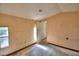 Empty bedroom showing window and entry door within peach colored interior at 1294 1/2 38Th Nw St, Winter Haven, FL 33881