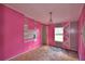 Pink bedroom with decorative wall, chandelier, and window view at 1294 1/2 38Th Nw St, Winter Haven, FL 33881