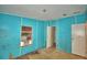 Corner view of bedroom with blue walls, window air conditioning unit and damaged flooring at 1294 1/2 38Th Nw St, Winter Haven, FL 33881