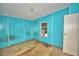 View of bedroom with blue walls, window air conditioning unit and damaged flooring at 1294 1/2 38Th Nw St, Winter Haven, FL 33881