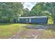 Mobile home exterior showing the entrance, surrounding trees, and spacious lot at 1294 1/2 38Th Nw St, Winter Haven, FL 33881