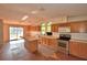 Bright kitchen equipped with stainless steel appliances, lots of wooden cabinets, a central island and glass sliding doors at 1294 1/2 38Th Nw St, Winter Haven, FL 33881