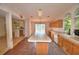 View of the kitchen with an island, wooden cabinets, sink and faucet, and a sliding glass door to the exterior at 1294 1/2 38Th Nw St, Winter Haven, FL 33881