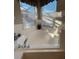 Bathroom showcasing a tiled corner tub and fixtures near a bright window at 135 Minniehaha Cir, Haines City, FL 33844