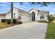 Bright, inviting home with a two-car garage, landscaped garden, and a vibrant blue front door at 135 Minniehaha Cir, Haines City, FL 33844