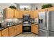 Well-lit kitchen with stainless steel appliances, wooden cabinets, and granite countertops at 135 Minniehaha Cir, Haines City, FL 33844