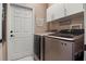 Convenient laundry room with modern washer and dryer units next to a white door at 135 Minniehaha Cir, Haines City, FL 33844