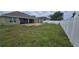 Expansive backyard with lawn, white fence, and covered patio seating area at 1400 Eagle Crest Blvd, Winter Haven, FL 33881