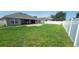 Large grassy backyard enclosed with a white vinyl fence offers ample space and privacy at 1400 Eagle Crest Blvd, Winter Haven, FL 33881