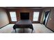 Spacious bedroom featuring two windows, dark walls and trim, and a tray ceiling with modern lighting at 1400 Eagle Crest Blvd, Winter Haven, FL 33881
