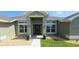 Charming front entrance with a decorative wreath, complemented by elegant outdoor lighting and tasteful landscaping at 1400 Eagle Crest Blvd, Winter Haven, FL 33881