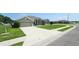 Expansive front yard showcasing a lush green lawn, featuring a long driveway leading to an attached two-car garage at 1400 Eagle Crest Blvd, Winter Haven, FL 33881