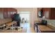 Functional kitchen with dark wood cabinets, stainless steel appliances, and a view into the adjoining room at 1400 Eagle Crest Blvd, Winter Haven, FL 33881