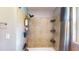 Tiled shower stall features a shower head, shelves, and a curtain for privacy in this renovated bathroom at 1515 W Lake Cannon Nw Dr, Winter Haven, FL 33881