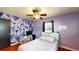 Bright bedroom offers hardwood floors, natural lighting, and geometric accent wall for a cozy living space at 1515 W Lake Cannon Nw Dr, Winter Haven, FL 33881