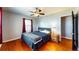 Comfortable bedroom featuring hardwood floors, ceiling fan and access to hallway at 1515 W Lake Cannon Nw Dr, Winter Haven, FL 33881