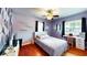Comfortable bedroom boasts a ceiling fan, hardwood floors, and colorful geometric accent wall for a vibrant atmosphere at 1515 W Lake Cannon Nw Dr, Winter Haven, FL 33881