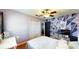 Stylish bedroom featuring wood floors, closet, ceiling fan and geometric accent wall with bright natural lighting at 1515 W Lake Cannon Nw Dr, Winter Haven, FL 33881