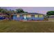 Charming blue home boasts a well-manicured lawn and inviting entryway with a sidewalk and a landscaped garden at 1515 W Lake Cannon Nw Dr, Winter Haven, FL 33881