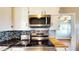 Kitchen featuring stainless steel appliances, a wooden ceiling, and white cabinets at 1515 W Lake Cannon Nw Dr, Winter Haven, FL 33881