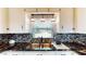 Kitchen boasts modern lighting fixtures above a stainless steel sink and a granite countertop at 1515 W Lake Cannon Nw Dr, Winter Haven, FL 33881