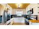 Kitchen showcases stainless steel appliances, dark granite countertops, and white cabinets with a wooden ceiling at 1515 W Lake Cannon Nw Dr, Winter Haven, FL 33881