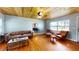 Open-concept living room with hardwood floors, wooden ceiling, modern furniture, and a view into the dining area at 1515 W Lake Cannon Nw Dr, Winter Haven, FL 33881