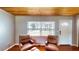 Cozy living room features hardwood floors, wooden ceiling, and a bright window with a front yard view at 1515 W Lake Cannon Nw Dr, Winter Haven, FL 33881