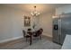 Dining room with modern lighting, stainless steel refrigerator and seating for four at 1700 6Th Nw St # C26, Winter Haven, FL 33881