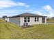 View of the backyard that showcases the exterior of the home, windows, and well-maintained lawn at 1752 Forest Run Ln, Auburndale, FL 33823