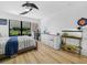 Well-lit bedroom with light hardwood floors, a ceiling fan, and a large window offering scenic views at 1850 S Lake Reedy Blvd, Frostproof, FL 33843