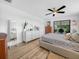 Bright bedroom with wood floor, ceiling fan, a dresser, and sliding door to porch at 1850 S Lake Reedy Blvd, Frostproof, FL 33843