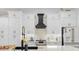 Kitchen featuring a black range hood, marble countertop, white cabinets and stainless appliances at 1850 S Lake Reedy Blvd, Frostproof, FL 33843