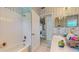 Bright bathroom with white tiled tub, open doorway and patterned wallpaper at 1902 Southern Dunes Blvd, Haines City, FL 33844