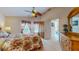 Cozy bedroom with floral bedding, matching curtains, ceiling fan, and ample closet space at 1902 Southern Dunes Blvd, Haines City, FL 33844