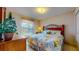 Well-lit bedroom with decorative bed frame, floral bedding, and window with blind and curtains at 1902 Southern Dunes Blvd, Haines City, FL 33844