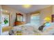 Bright bedroom with floral bedding, wooden dresser with mirror, and view into the hallway at 1902 Southern Dunes Blvd, Haines City, FL 33844