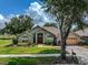 Landscaped home exterior with a paved walkway, double front doors, and arched entryway at 1902 Southern Dunes Blvd, Haines City, FL 33844