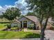 Charming single-story home with lush landscaping, brick walkway, and two-car garage at 1902 Southern Dunes Blvd, Haines City, FL 33844